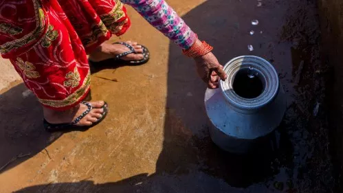Eine Frau fängt Wassertropfen mit einem Krug auf