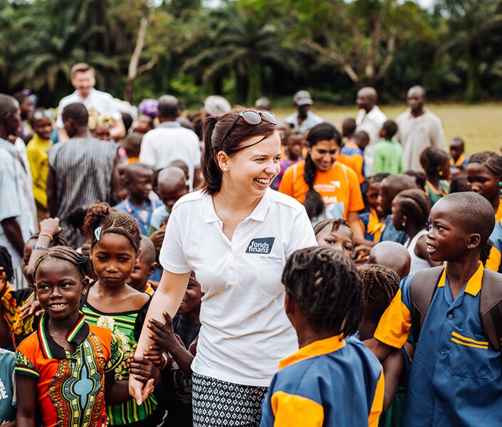 CSR-Managerin Irmgard Dietmair umringt von Kindern in Afrika