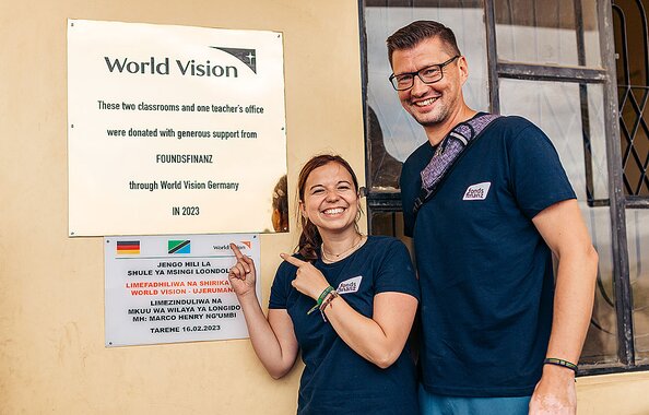 Irmi und Simon vom CSR-Team der Fonds Finanz vor der Schule im Dorf Loondolwa in der Region Ketumbeine in Tansania, die mit Spendengeldern der Fonds Finanz gebaut wurde