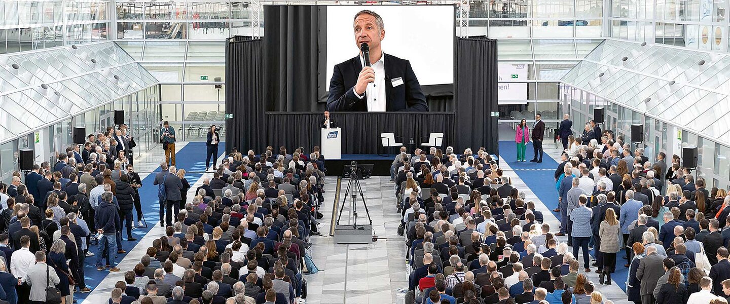 Fonds Finanz Geschäftsführer Norbert Porazik als Speaker vor vollem Saal bei der MMM-Messe 2024 in München