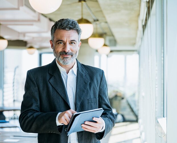 Ein Makler mit Tablet in der Hand, mit dem er sich gerade vom Newsletter abgemeldet hat