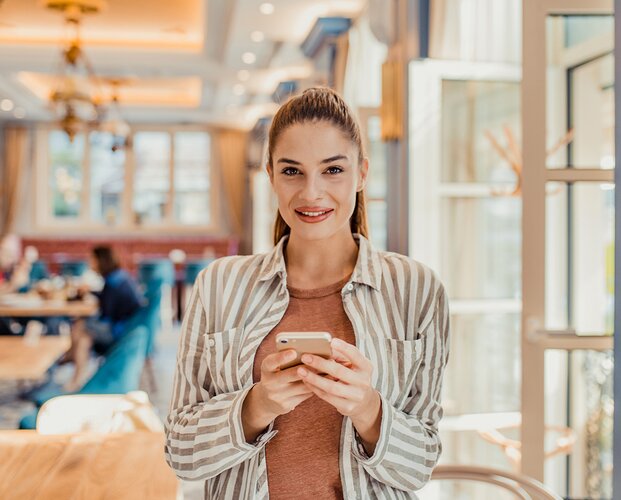 Eine junge Maklerin mit Handy in der Hand