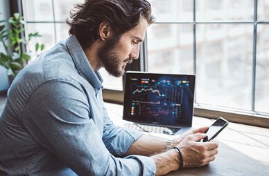 Ein Vermittler am Bildschirm beim Verwalten von Investmentfonds und Vermögensverwaltungen