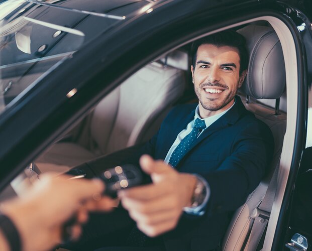 Ein Vermittler in einem Auto, das er über die Partnerangebote der Fonds Finanz geleast hat