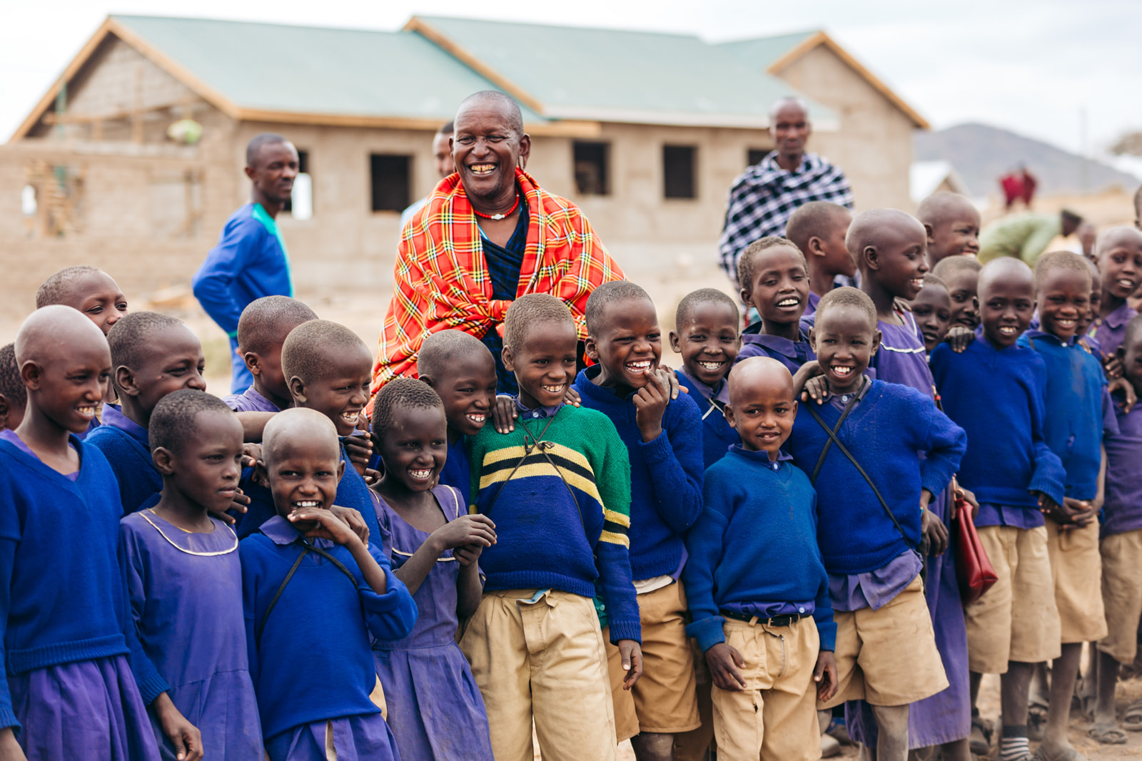 Lachende Schulkinder und ihre Lehrer in Tansania