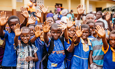Fröhlich winkende Schulkinder vor der Grundschule in Tongia in Sierra Leone