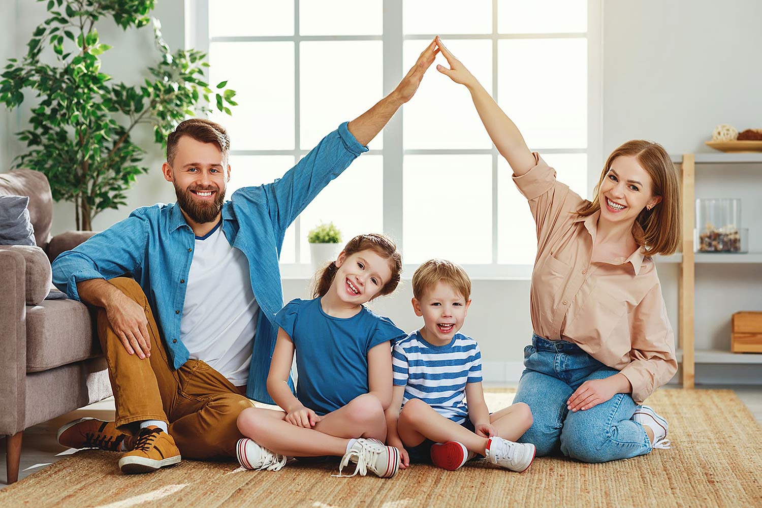 Ein junges Paar mit ihren beiden kleinen Kindern im Wohnzimmer