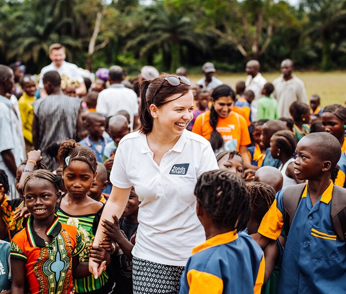 CSR-Managerin Irmgard Dietmair umringt von Kindern in Afrika