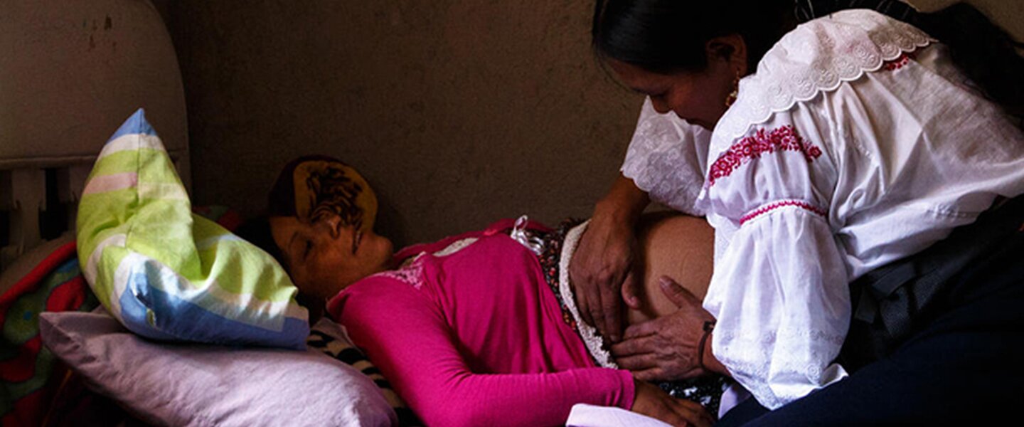 Eine Helferin untersucht eine schwangere Frau in Bolivien