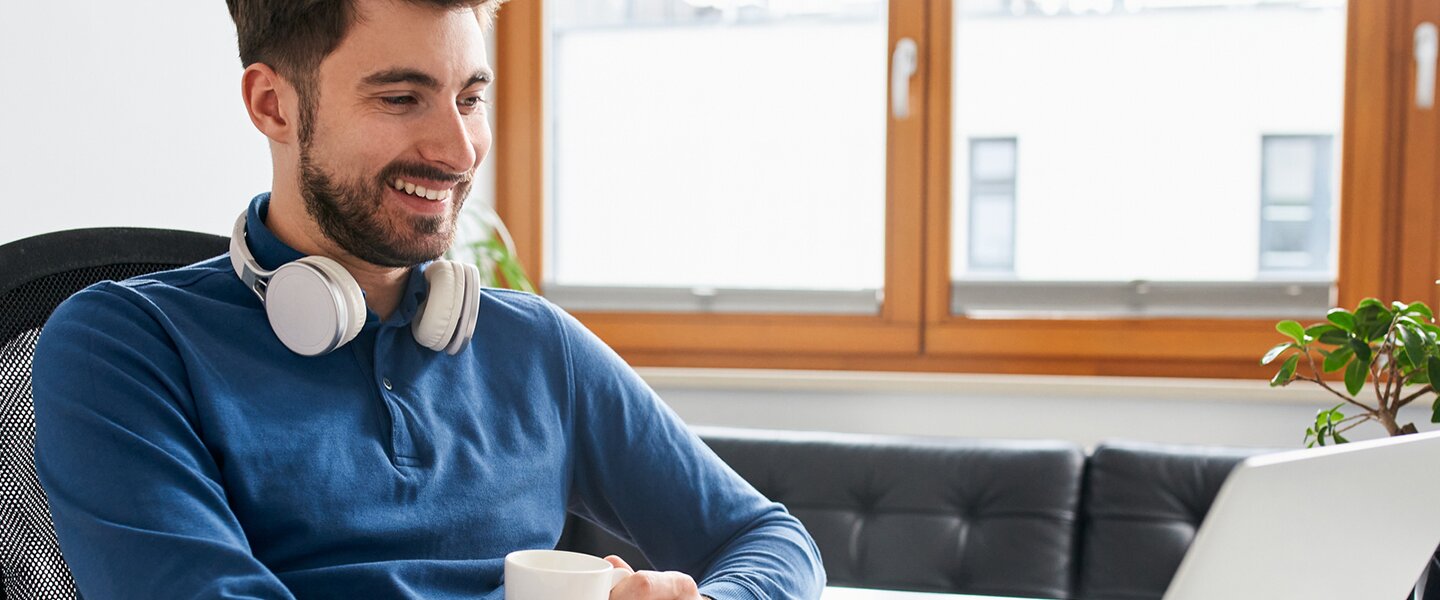 Ein Vermittler von Baufinanzierungen, der am Laptop beim Web-Based-Training der Fonds Finanz teilnimmt