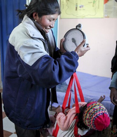 Mutter wiegt Kind in Bolivien