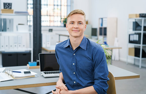 Ein junger Berufseinsteiger am Schreibtisch