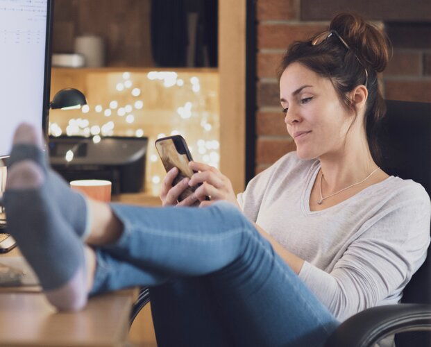 Eine Frau, die sich für den HR-Newsletter der Fonds Finanz registriert hat und nun Infos über neue offene Stellen im Unternehmen liest