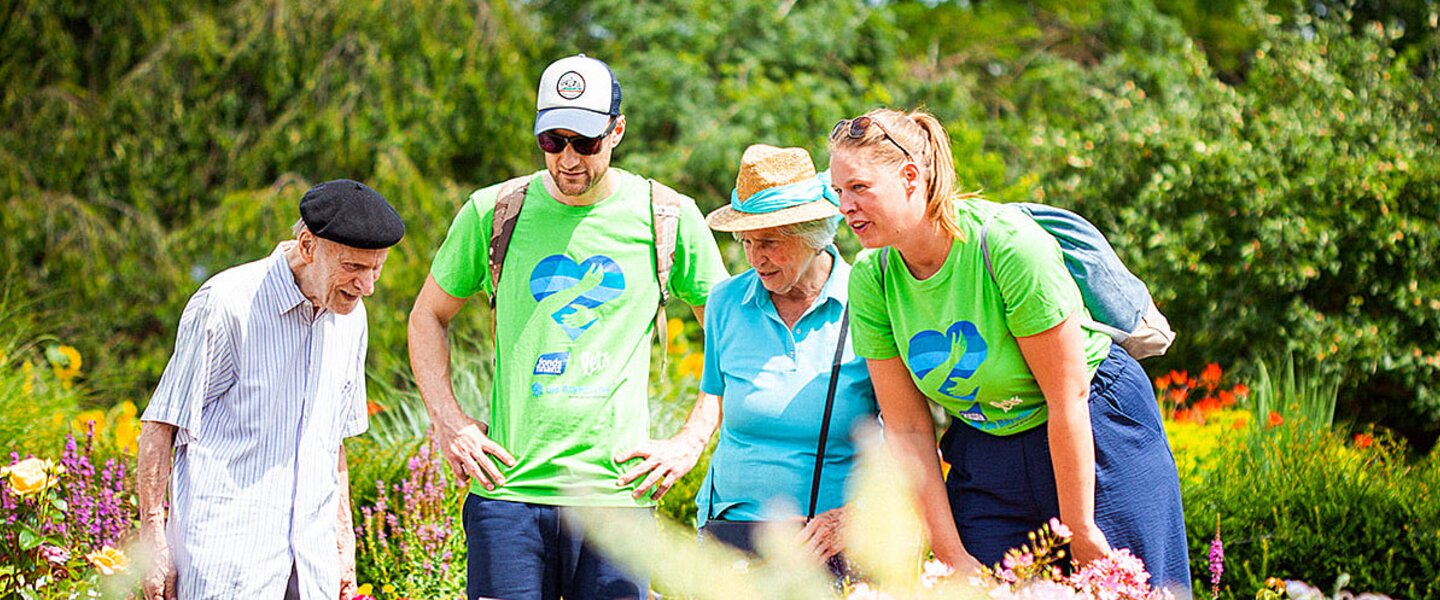 Teilnehmer der Social Week 2023, die sich ehrenamtlich für soziale Projekte engagieren, zusammen mit Senioren im Botanischen Garten in München