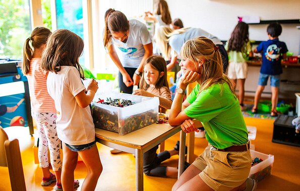 Ehrenamtliche Helferinnen beim Spielen mit Kindern des Arche-Projekts in München