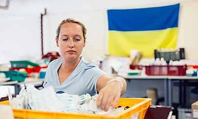 Eine ehrenamtliche Helferin beim Sortieren von Medizinspenden für Menschen in der Ukraine