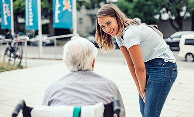 Eine ehrenamtliche Teilnehmerin der Social Week im Gespräch mit einem Senior