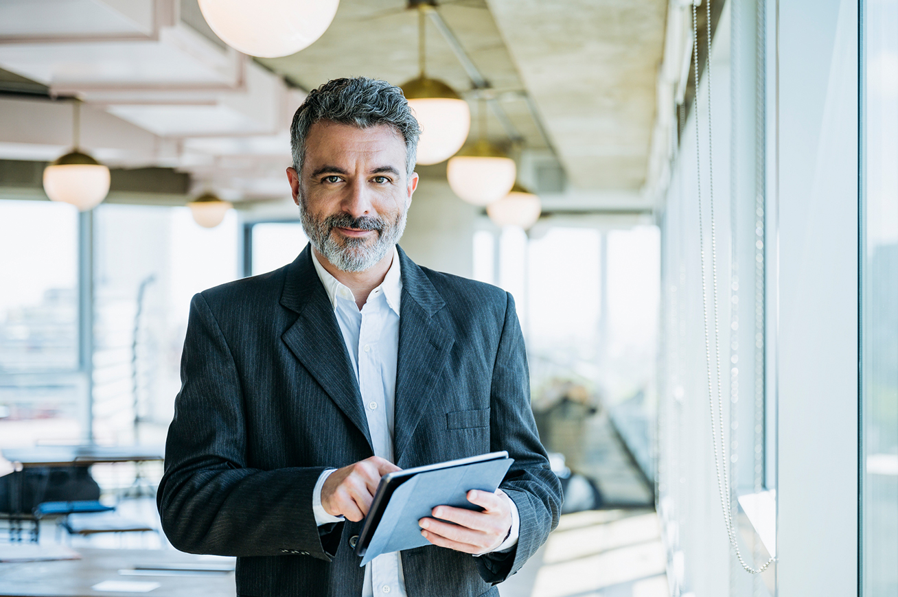 Ein Makler mit Tablet in der Hand, mit dem er sich gerade vom Newsletter abgemeldet hat
