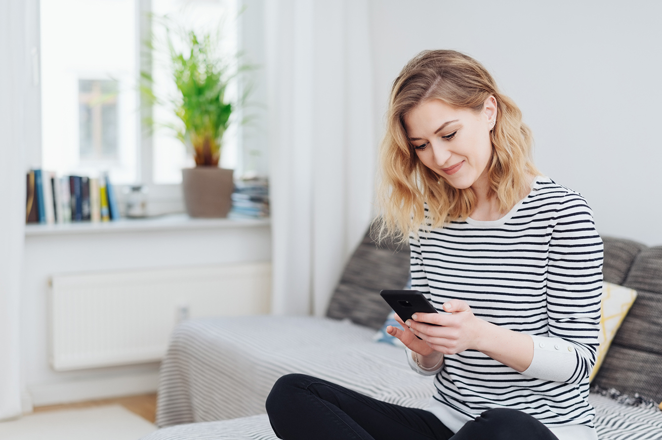 Bild mit einer Frau, die auf ihr Handy schaut, als Bild zur Newsletter-Registrierung, bei der der Verifizierungslink abgelaufen ist