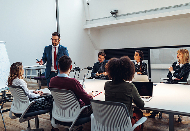 Makler in einem Meeting, in dem sie eine Strategie entwickeln, wie sie mit Social Selling erfolgreich das Business-Netzwerk Xing nutzen können