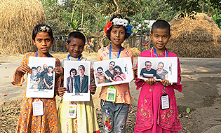 Kinder, die ein Foto ihrer Wunschpaten in den Händen halten